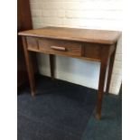 A George VI oak desk with rectangular rounded panelled top above a frieze with drawer, raised on
