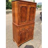 A mahogany cocktail cabinet with moulded cornice above cut-corner burr walnut panels to doors