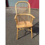 An elm windsor chair with hooped back on spindles having bow arms above a solid shaped seat,