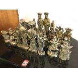 A cast iron oriental chess set, the heavy figures plated silver & bronze with stylised footsoldier