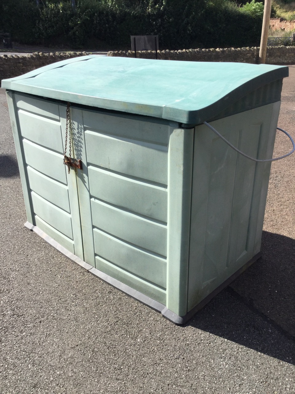 An outdoor storage cabinet with angled roof and two doors, the interior wired for electricity. (57. - Image 3 of 3