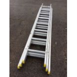 An aluminium extending ladder in three sections, each piece with eight ribbed treads. (95in)