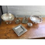 Six pieces of silver plate - two cruet sets on stands, a floral embossed rose bowl, a cake basket, a