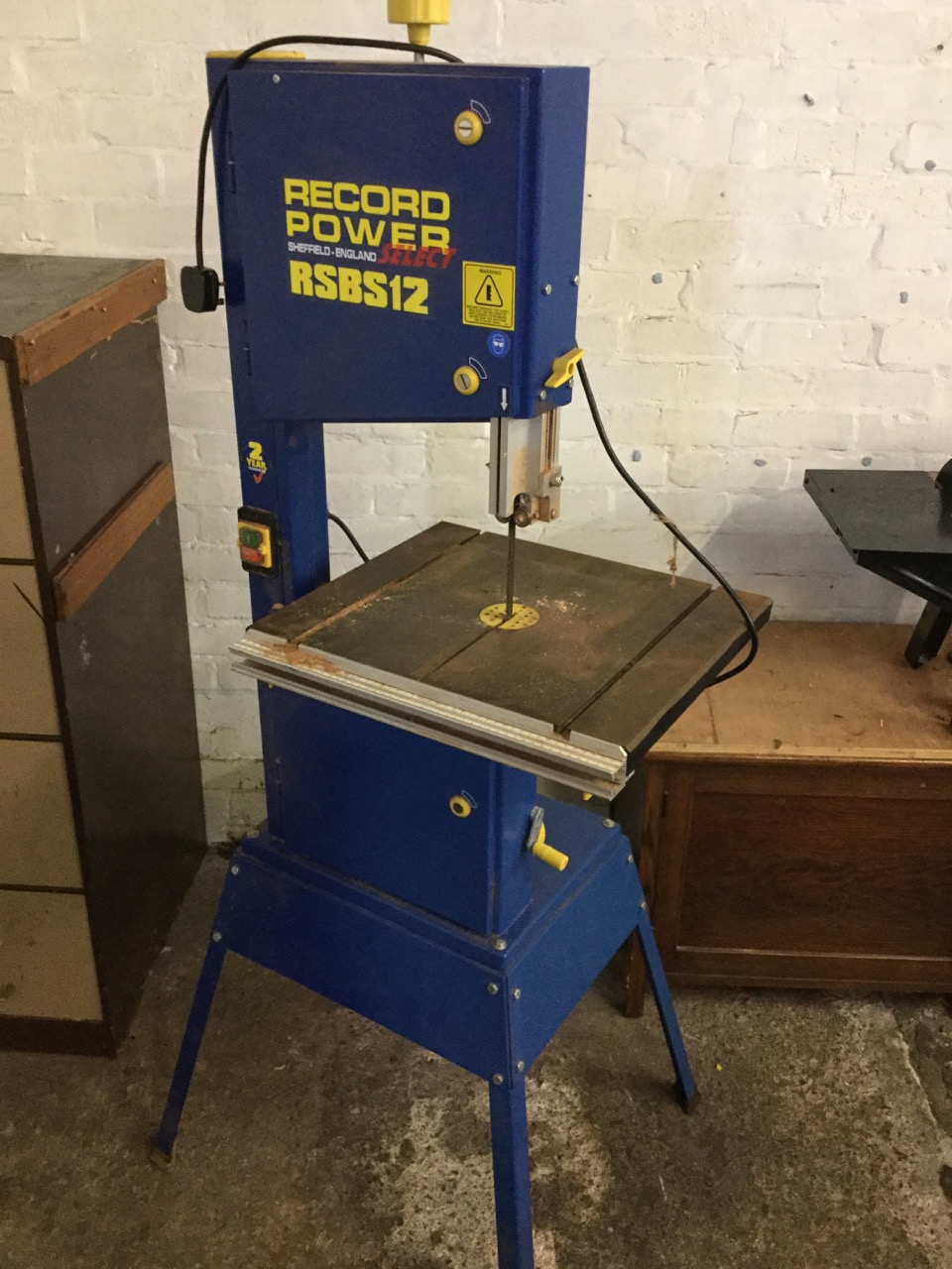 A Record RSBS 12 bandsaw, the machine with adjustable cutting table on angled legs.