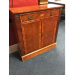 A yew side cabinet, the crossbanded top above a cockbeaded frieze drawer inlaid with oval shell