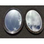 A pair of oval Edwardian mirrors with bevelled plates in grained moulded frames. (33.5in x 23.5in