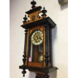 A Victorian Vienna style walnut wallclock, the shaped pediment with turned finials having applied