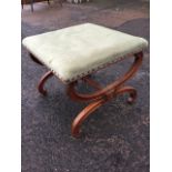 A Victorian walnut stool, the stud upholstered seat on twin scrolled channelled supports joined by