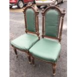 A pair of Victorian oak hall chairs, the foliate scroll carved arched backs and shields above