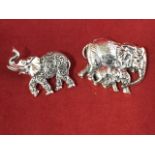 A Sterling silver brooch modelled as an elephant with raised trunk, having scrolled decoration to