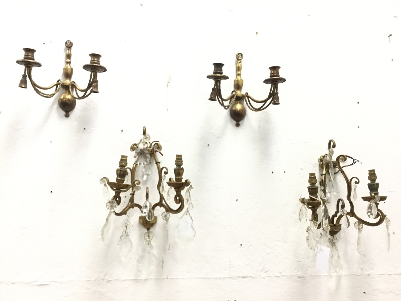 A pair of brass wall lights having scrolled branches hung with crystal drops; and another pair