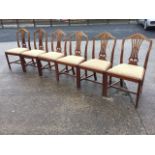 A set of six mahogany Hepplewhite style dining chairs, the shield shaped moulded backs framing