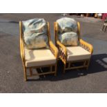 A pair of cane conservatory armchairs with lattice sides and curved twinned arms, the backs &