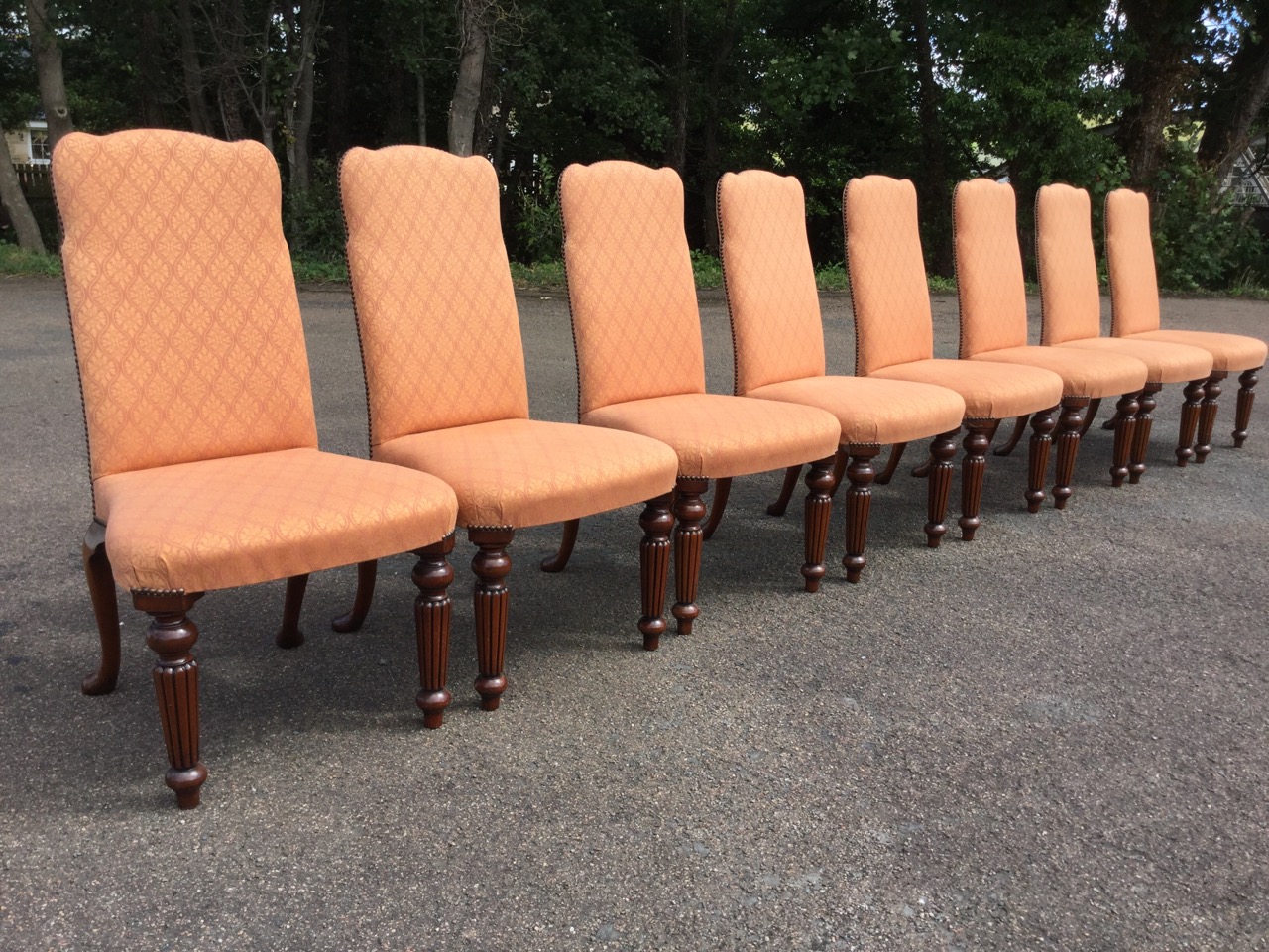 A set of eight Georgian style upholstered mahogany dining chairs, the shaped padded brass studded