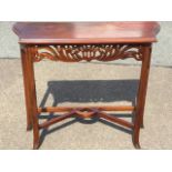 A mahogany hall table with shaped moulded top above a fretwork cut pierced frieze, raised on