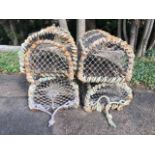 Four lobster pots with arched metal rope bound frames, each with three apertures and opening