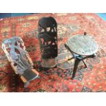 A pair of African tribal carved birthing chairs, the pierced backs with giraffes, lions,
