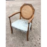 A walnut armchair, the octagonal back with circular cane panel having shaped arms on baluster