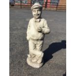 A composition stone figure of a golfer, the moustachioed gentleman holding a ball, leaning