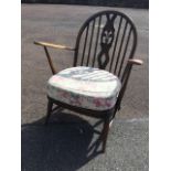 An Ercol Windsor style armchair, the hooped back on spindles framing a pierced splat with oval