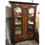 A Victorian walnut wardrobe with overhanging moulded cornice above a scroll carved shield panel