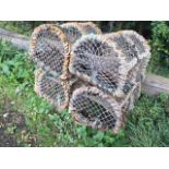 Four lobster pots, the arched metal frames rope bound, each with three apertures and opening