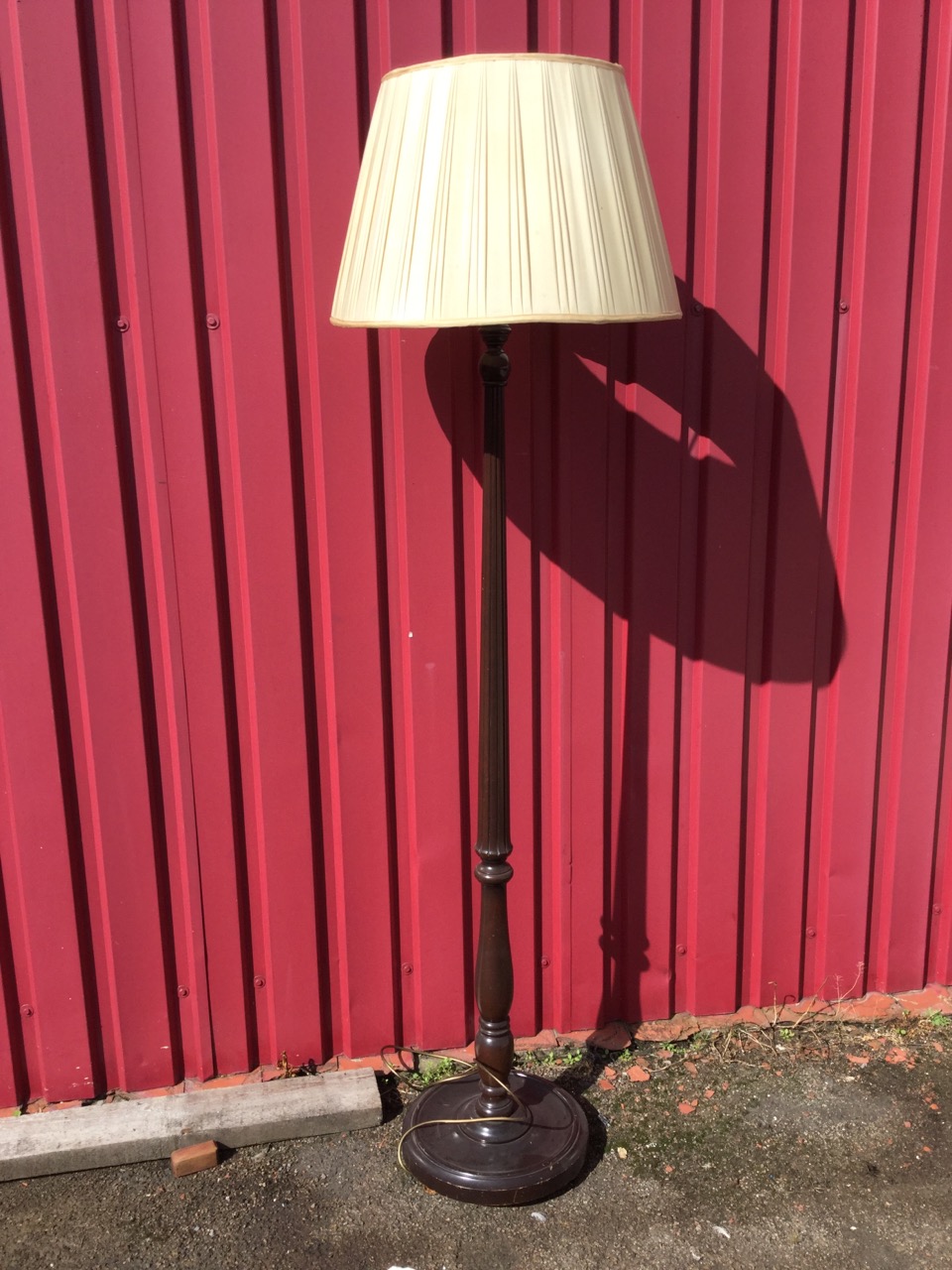 A mahogany standard lamp, the tapering fluted column above a baluster on circular saucer base,