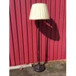 A mahogany standard lamp, the tapering fluted column above a baluster on circular saucer base,