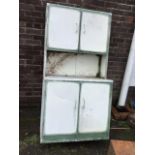 A painted aluminium kitchen cabinet with two doors above an open compartment with work surface,