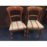 A married pair of Victorian mahogany chairs with arched backs above upholstered seats, raised on