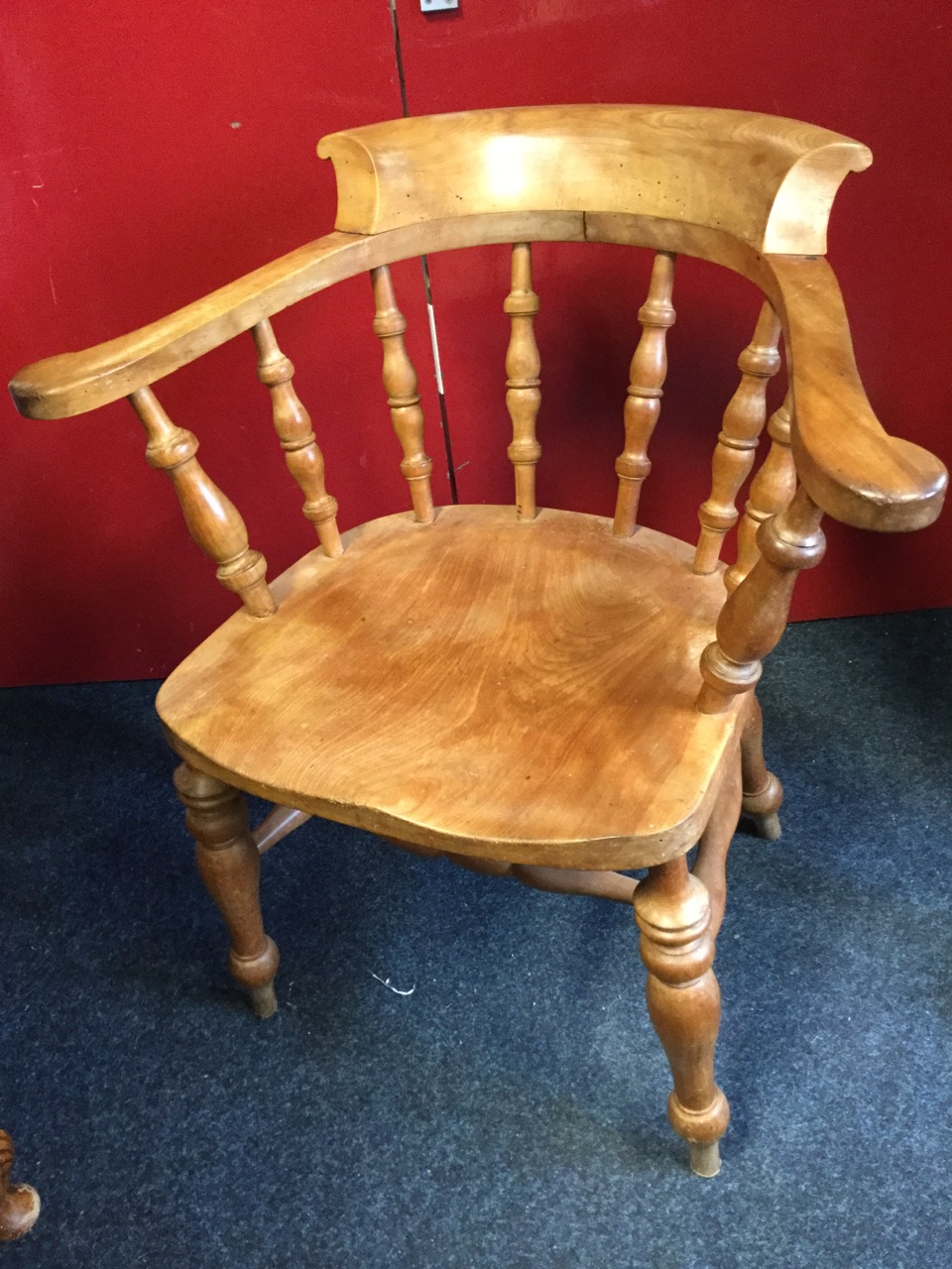 A mahogany captains chair, the shaped bow back on spindles above a solid seat, raised on turned legs