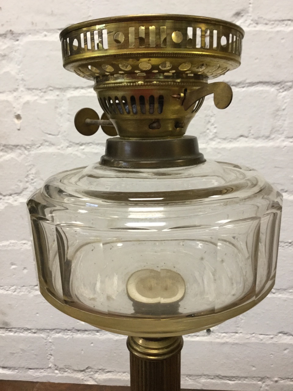 A Victorian brass oil lamp with chamfered bun shaped glass reservoir on fluted column above weighted - Image 2 of 3