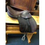 A Caroline Bradley leather saddle complete with stirrups.