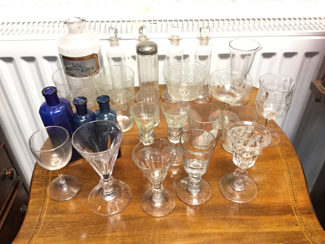 Miscellaneous glass including a set of four tubular jars with stoppers, a chemical bottle,