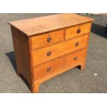 An art nouveau oak chest of drawers with two short and two long drawers mounted with original ring