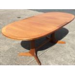 A 60s teak Ercol extending dining table with integral leaf, the crossbanded moulded top with rounded