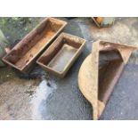 Two rectangular cast iron troughs with angled sides; and a cast triangular corner animal trough with