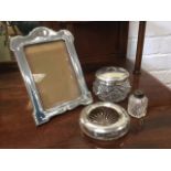 A hallmarked art nouveau silver photo frame on easel stand; a cut glass ladys hair jar with