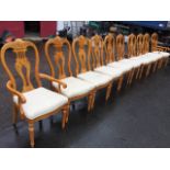 A set of ten Queen Anne style dining chairs with scroll carved backs above stuffover upholstered