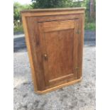 A Victorian dowel jointed oak corner cupboard with moulded panelled door enclosing shelves. (28in
