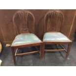 A pair of nineteenth century mahogany dining chairs, the arched backs carved with anthemion and