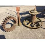 Two Victorian cast iron cog wheels from an old mill; and a cast iron stand with quatrefoil arrow