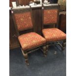 A pair of carved oak hall chairs with scrolled rails and chiselled stiles having knob finials,