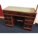 A reproduction mahogany kneehole desk, the crossbanded canted top with leather skiver above three