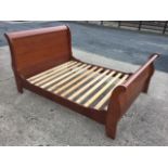 A mahogany sleigh bed with curved panelled headboard & tailboard, having shaped side rails with