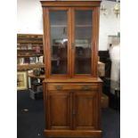 An Edwardian bookcase with moulded cornice above glazed doors enclosing adjustable shelves framed by