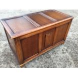 An oak blanket box of three panelled construction with fluted stiles, the central panel with applied