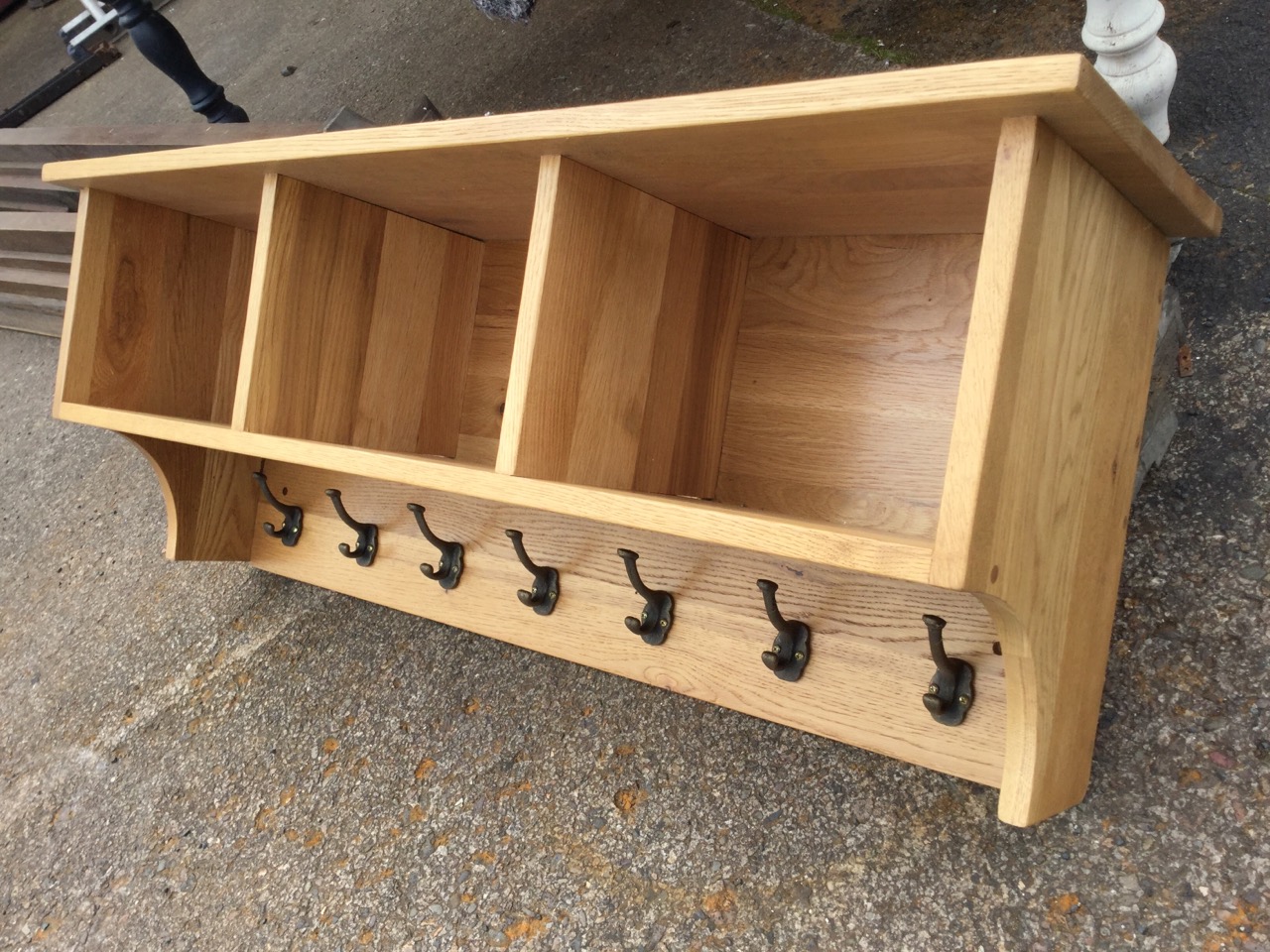 A contemporary oak hall rack, with shelf above three open compartments, having row of seven brass - Image 3 of 3