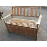 A hardwood garden bench, the arched back with pierced splats above a slatted box boarded seat, the