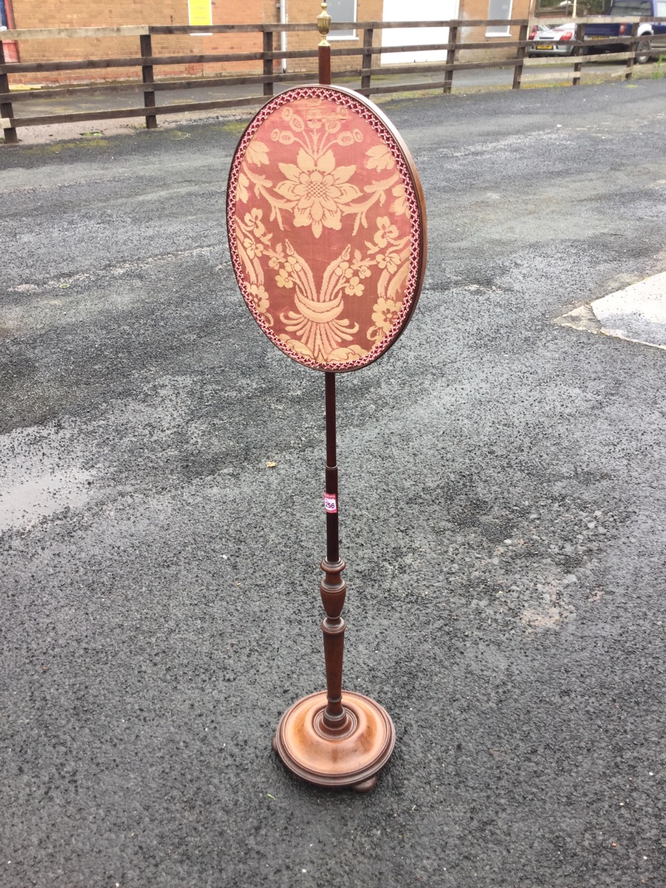 A nineteenth century mahogany pole screen with oval damask panel on turned column surmounted by